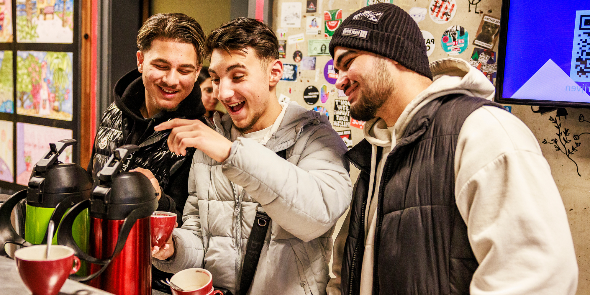 Enkele jongeren bedienen zichzelf van koffie Enkele jongeren bedienen zichzelf van koffie